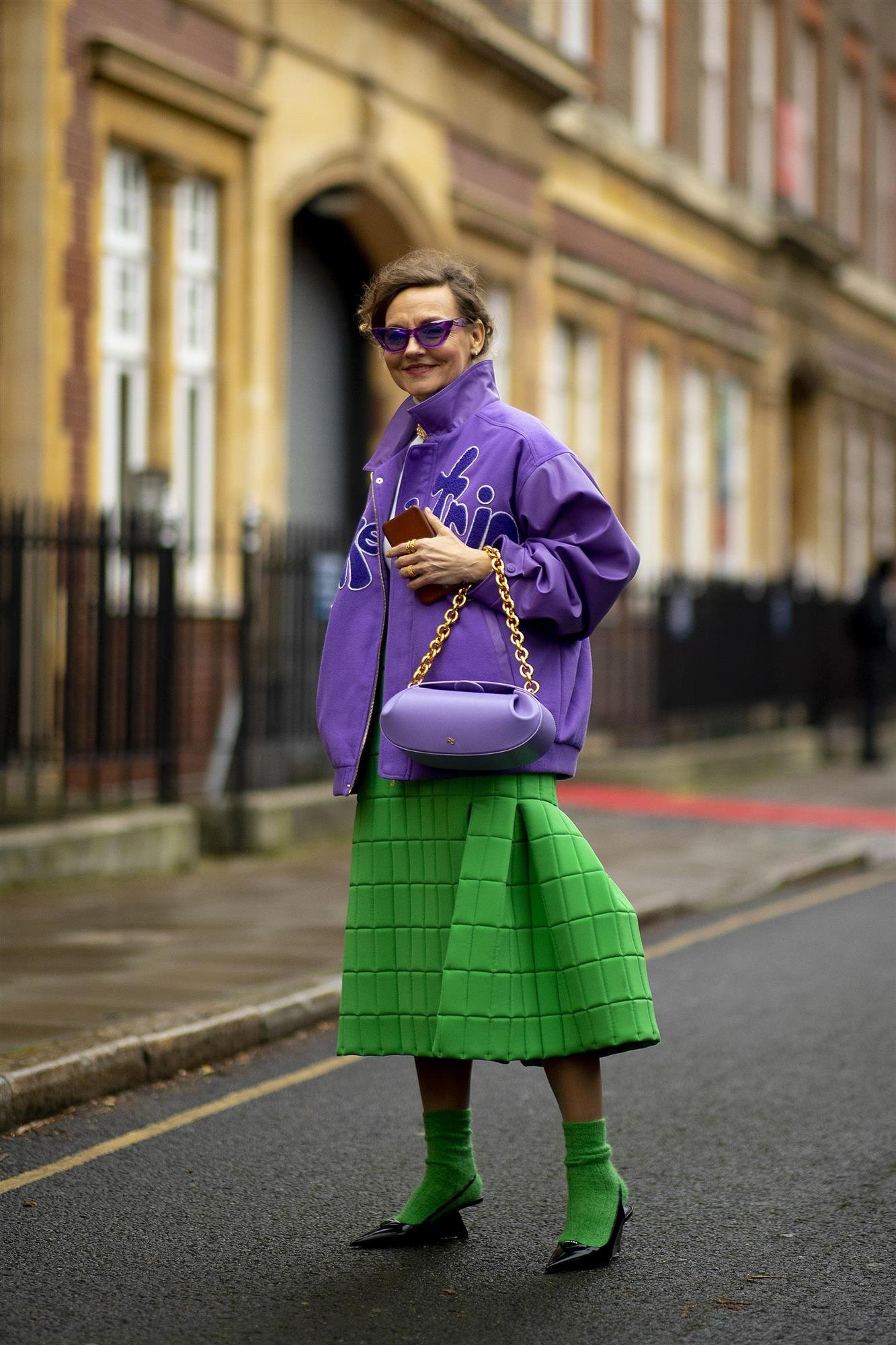 Woman wearing a purple jacket with a vivid green skirt