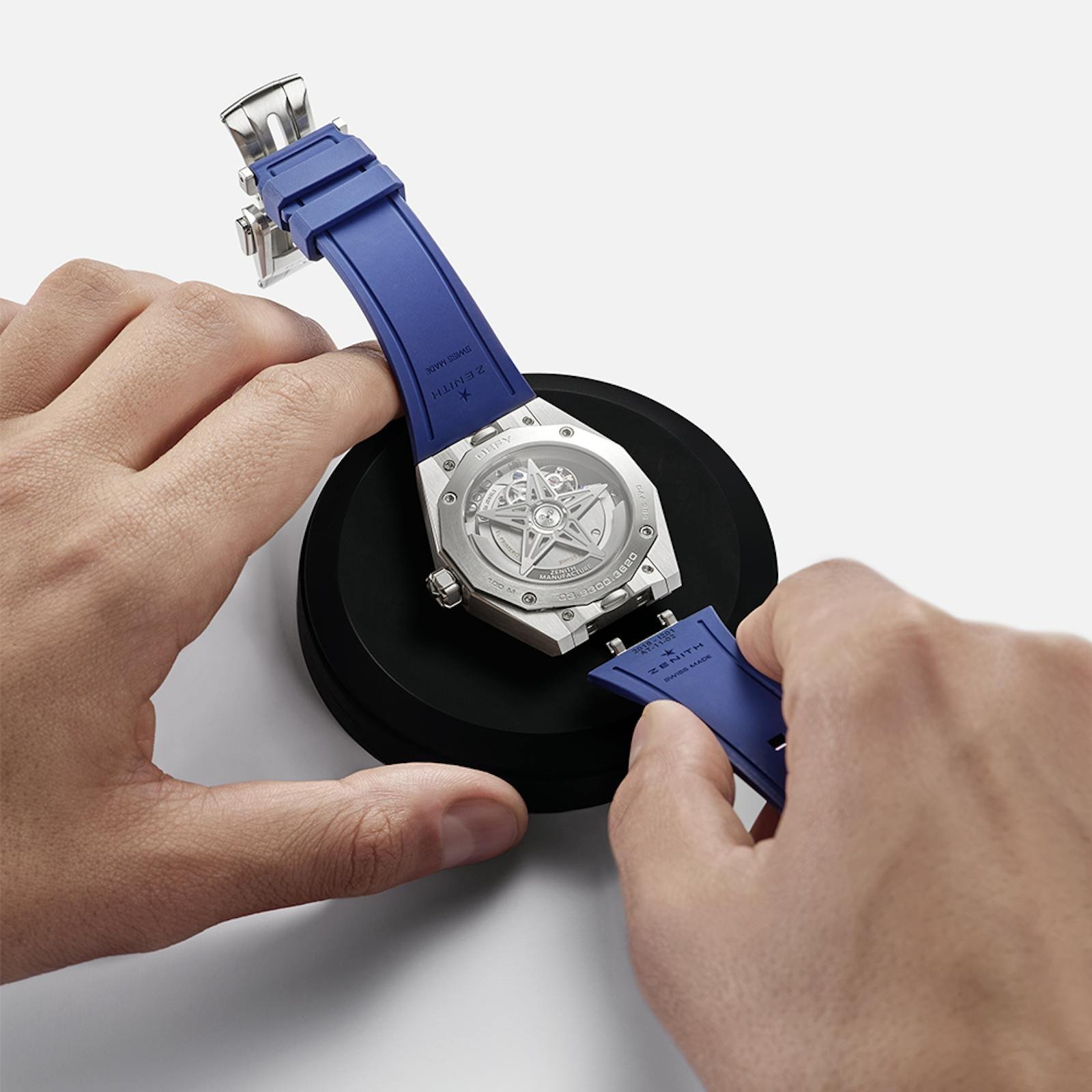 Watchmaker handling a Zenith watch and strap during maintenance.