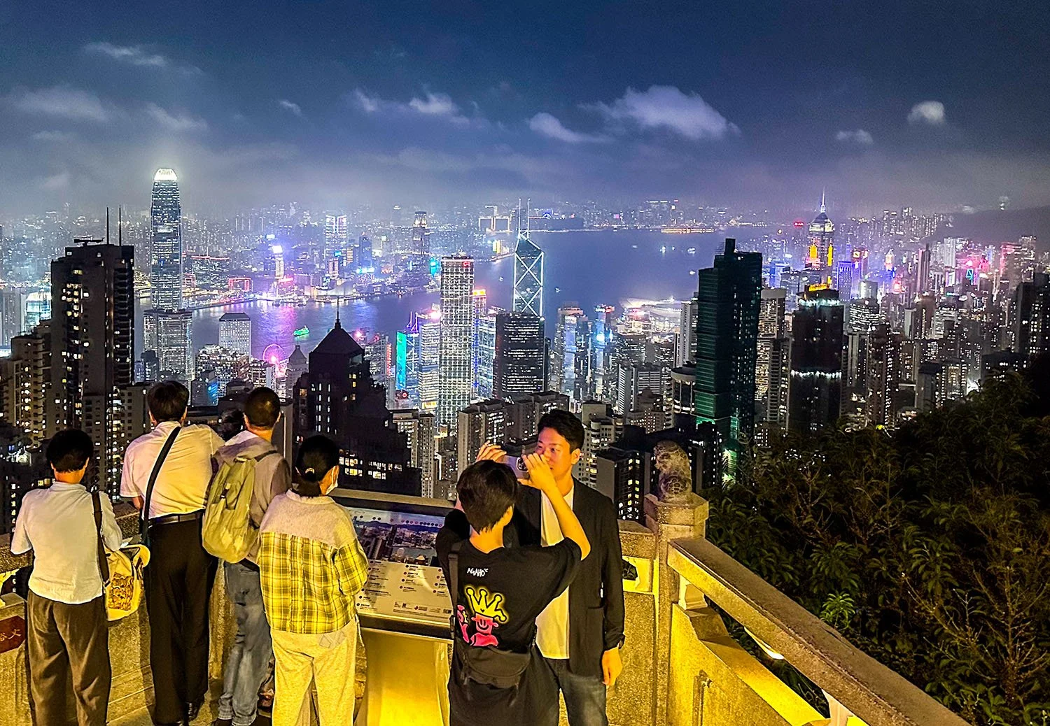 Visitors gathered at a Victoria Peak lookout above Hong Kong’s night skyline.