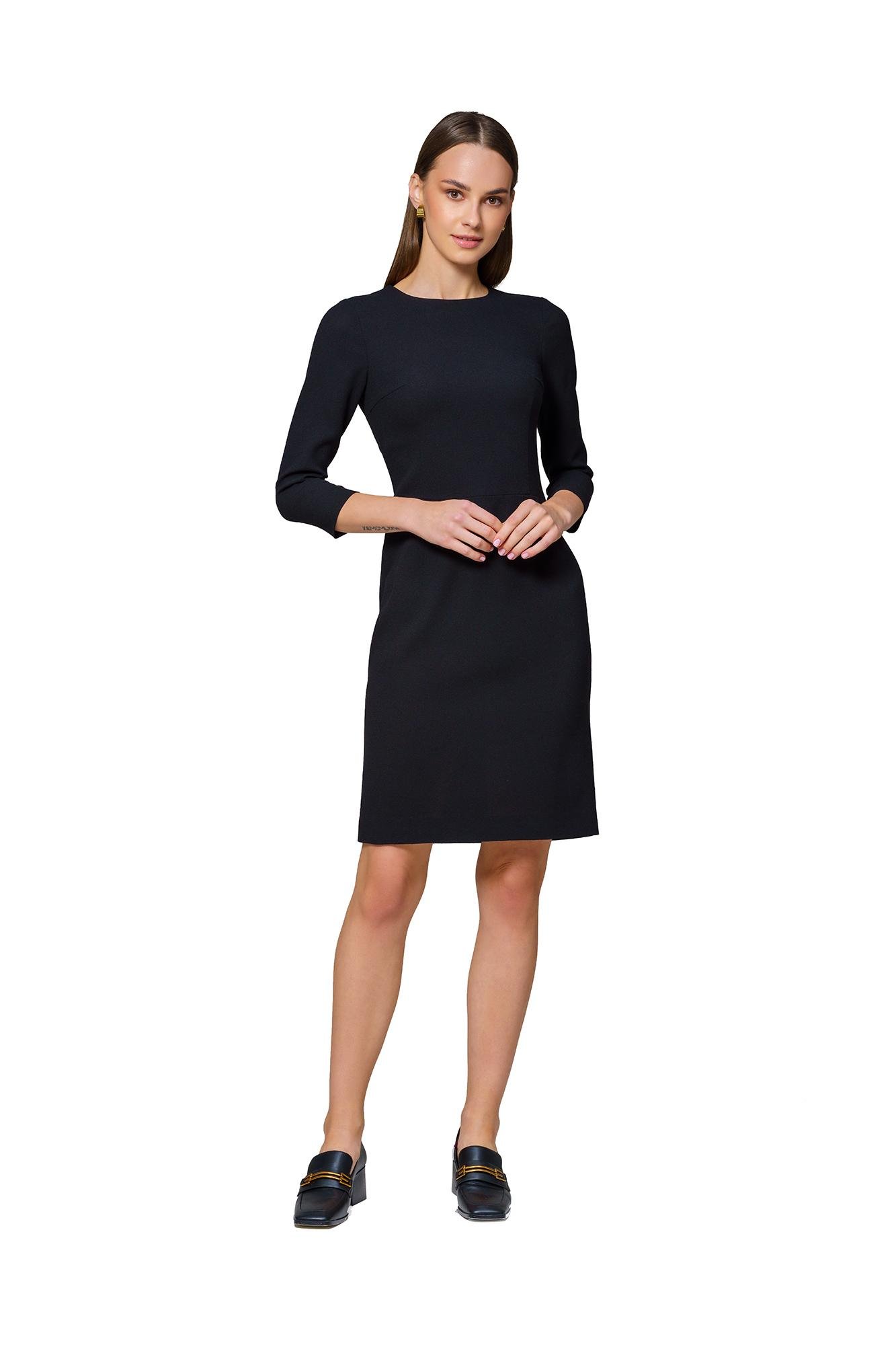 Woman wearing a tailored black sheath dress in a professional style.