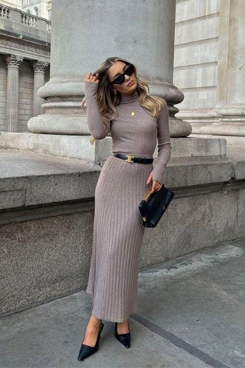 Woman wearing a refined knitted midi dress with a belt.