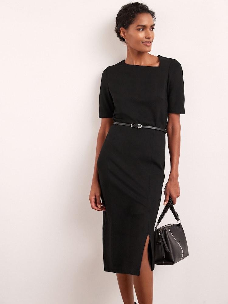 Woman wearing a structured black midi dress that maintains a clean silhouette.