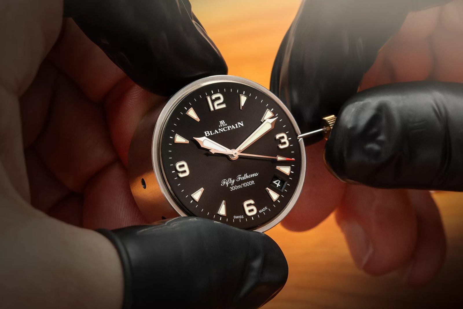 A watchmaker handling the luminous dial of a Blancpain Fifty Fathoms Automatique.