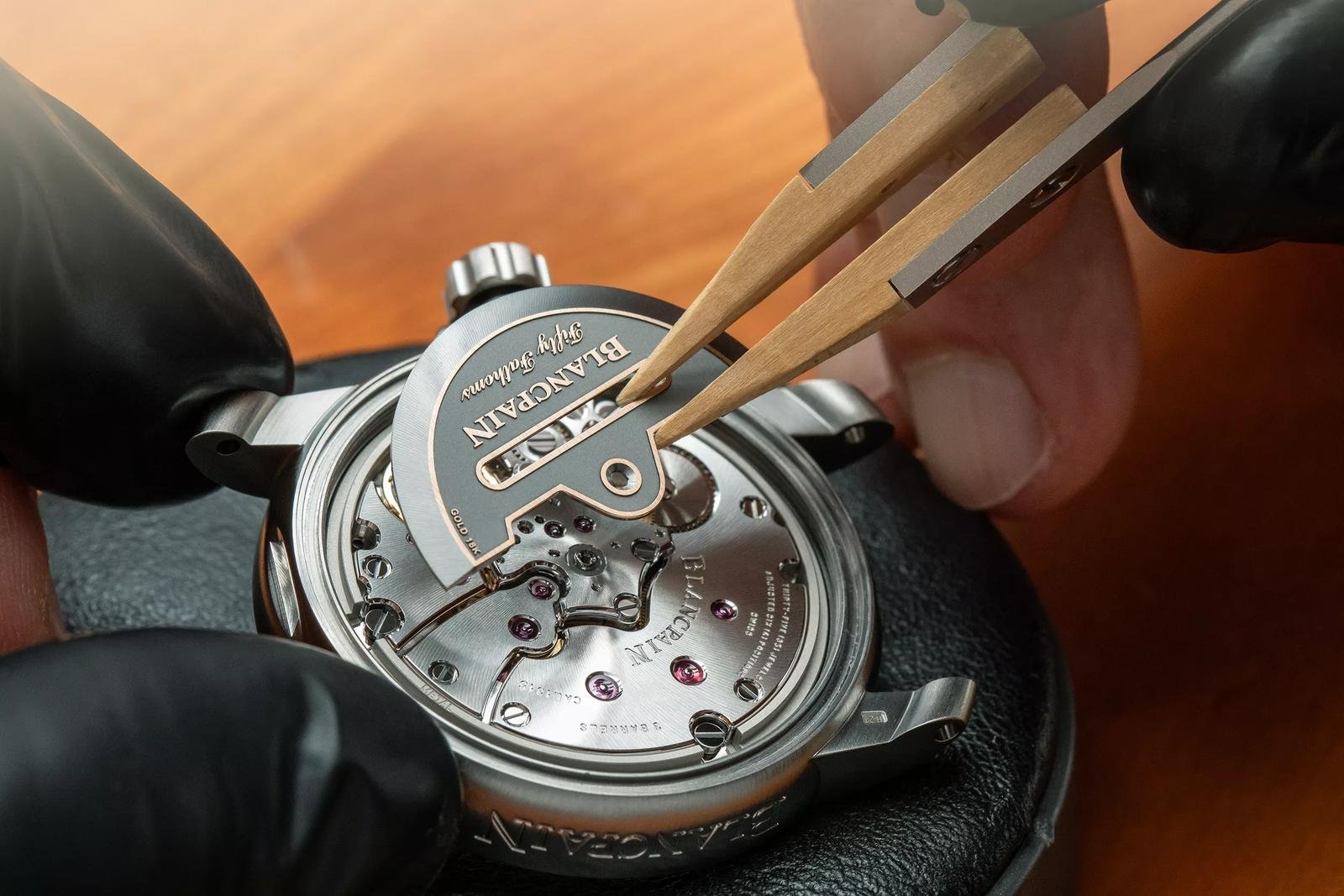 Watchmaker working on a Blancpain Fifty Fathoms movement in its case.