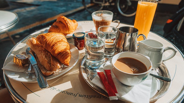 Coffee, croissants and juice on a Paris café table.