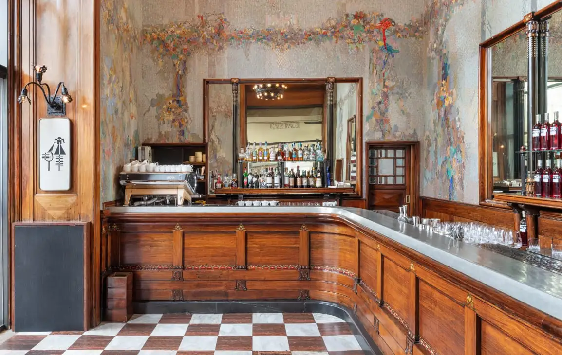 Camparino’s historic bar with wood counters and ornate wall decoration.