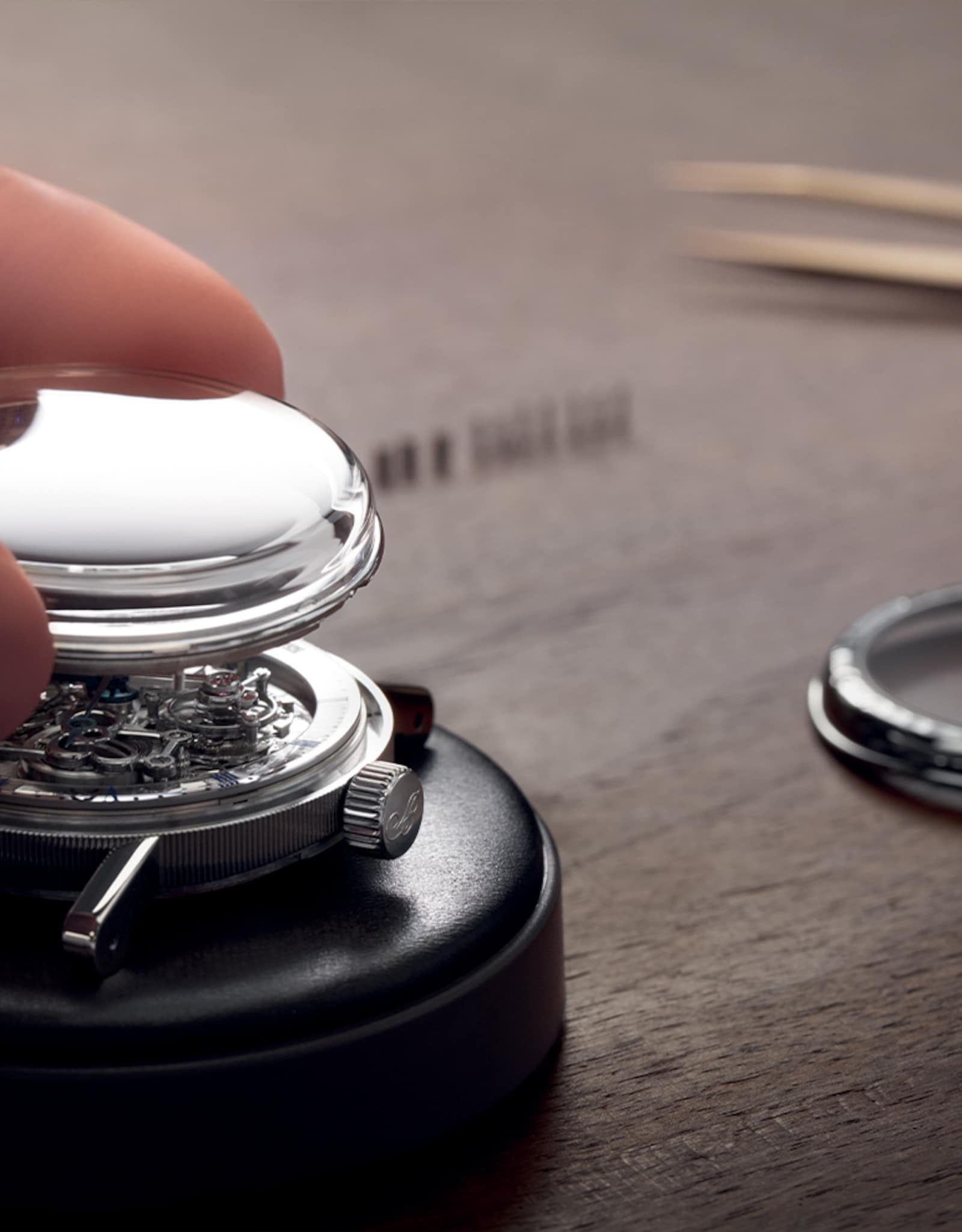 Watchmaker opening a Breguet watch case during servicing.