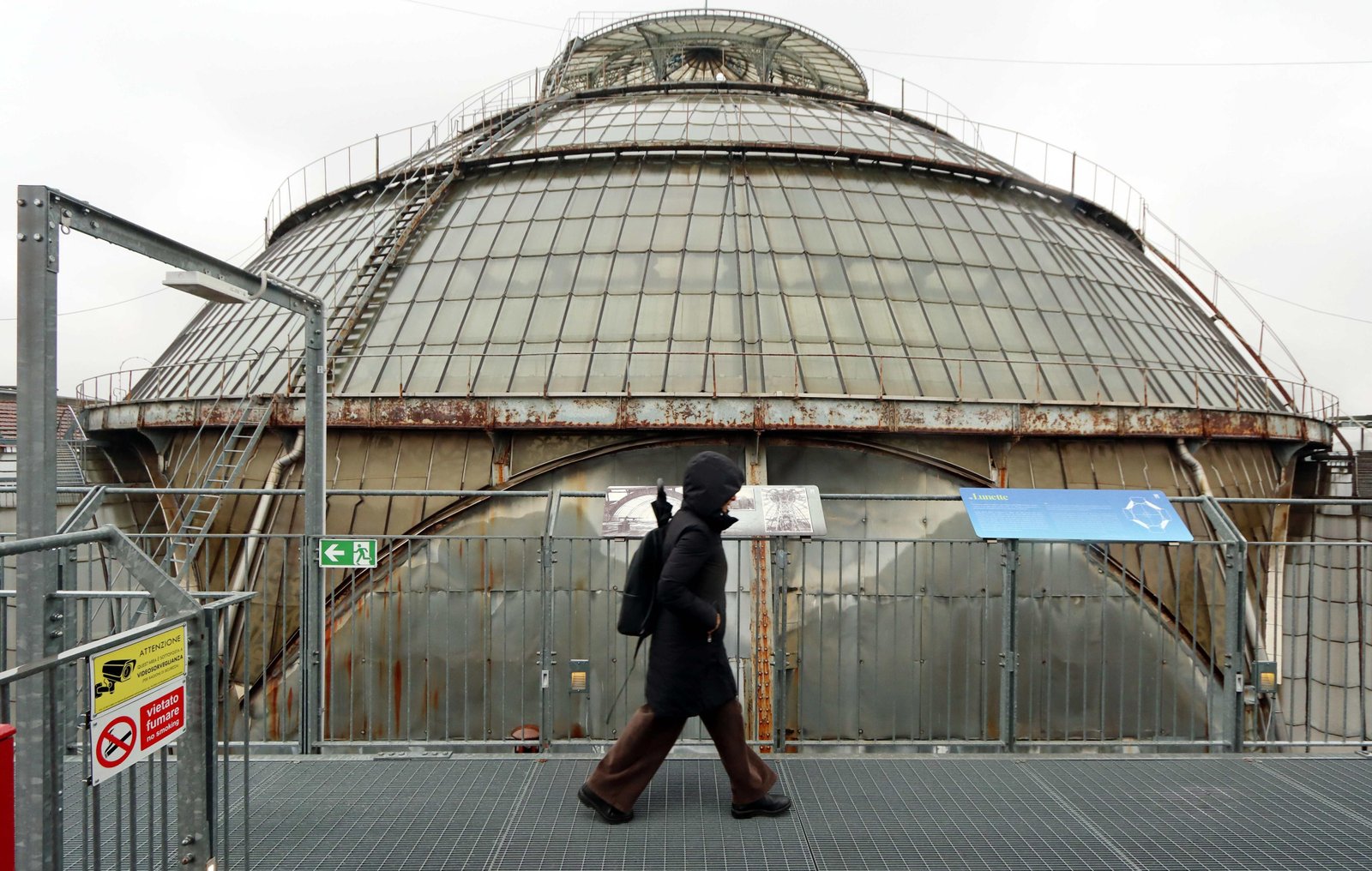 Visitor on a grated HIGHLINE rooftop walkway beside the glass dome.