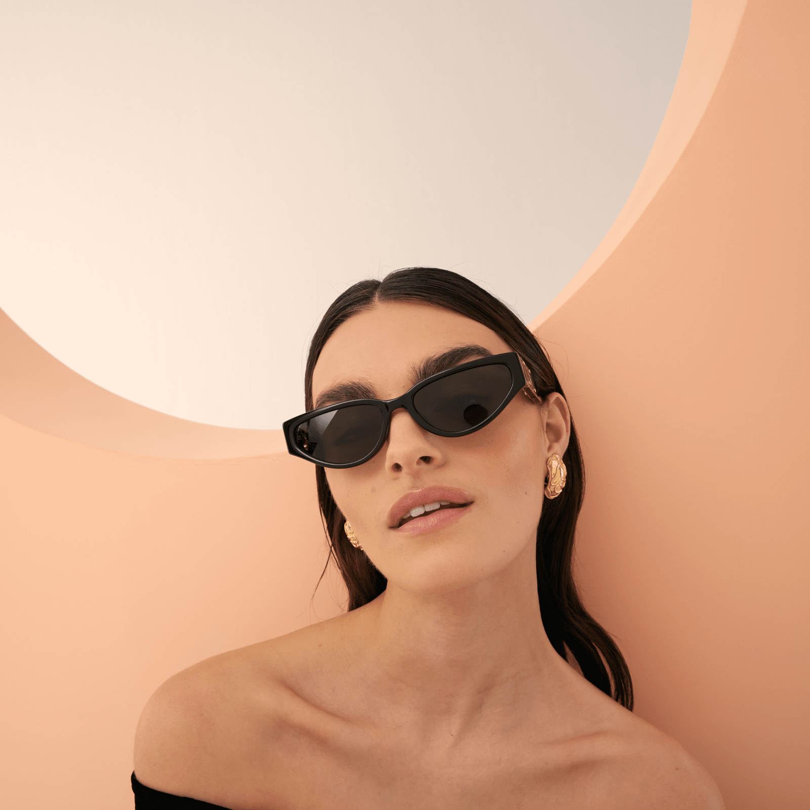 Model styling Linda Farrow Tomie cat-eye sunglasses in an editorial portrait.