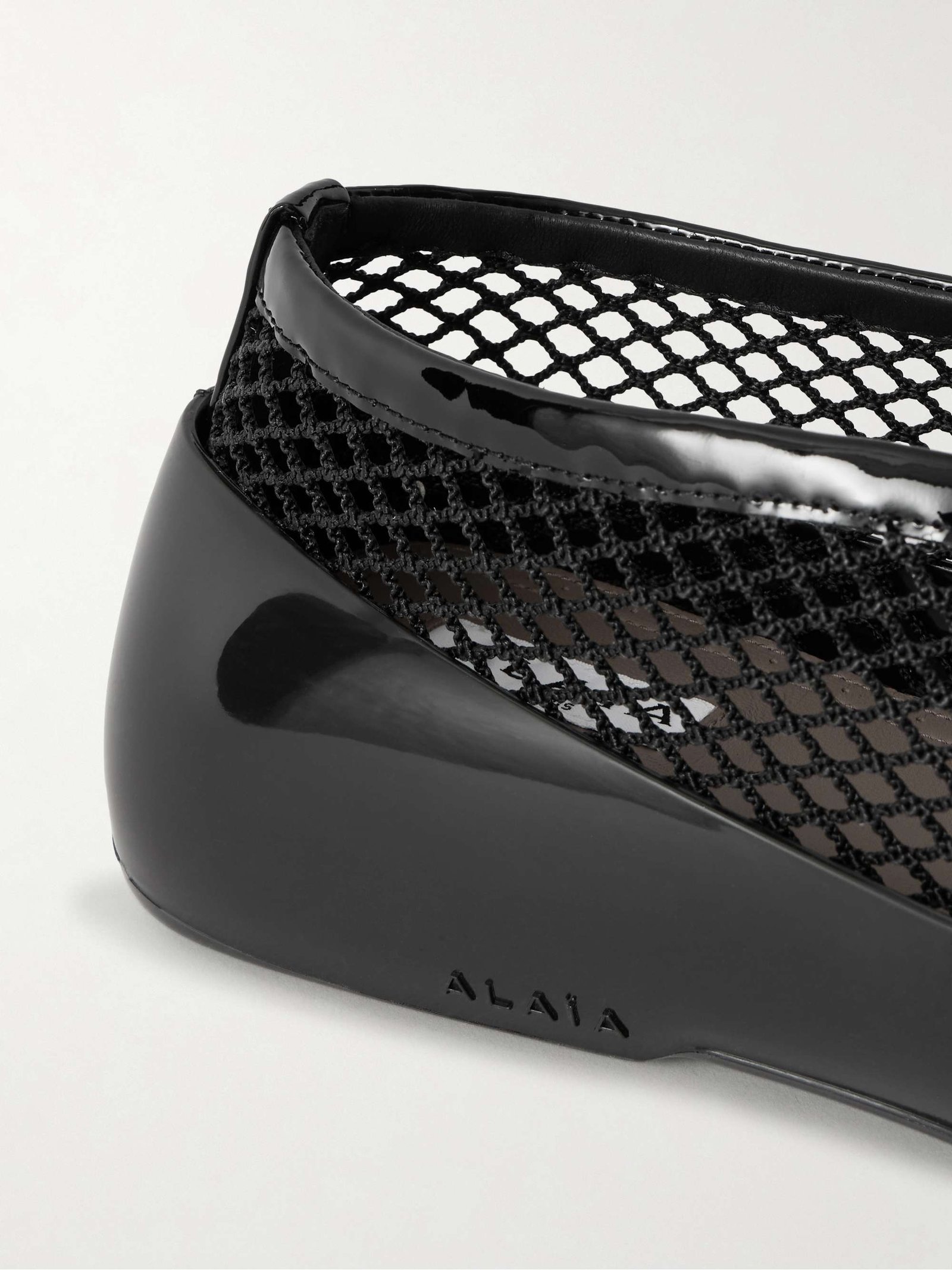 Close-up of mesh, leather edging and the heel of a ballet flat.