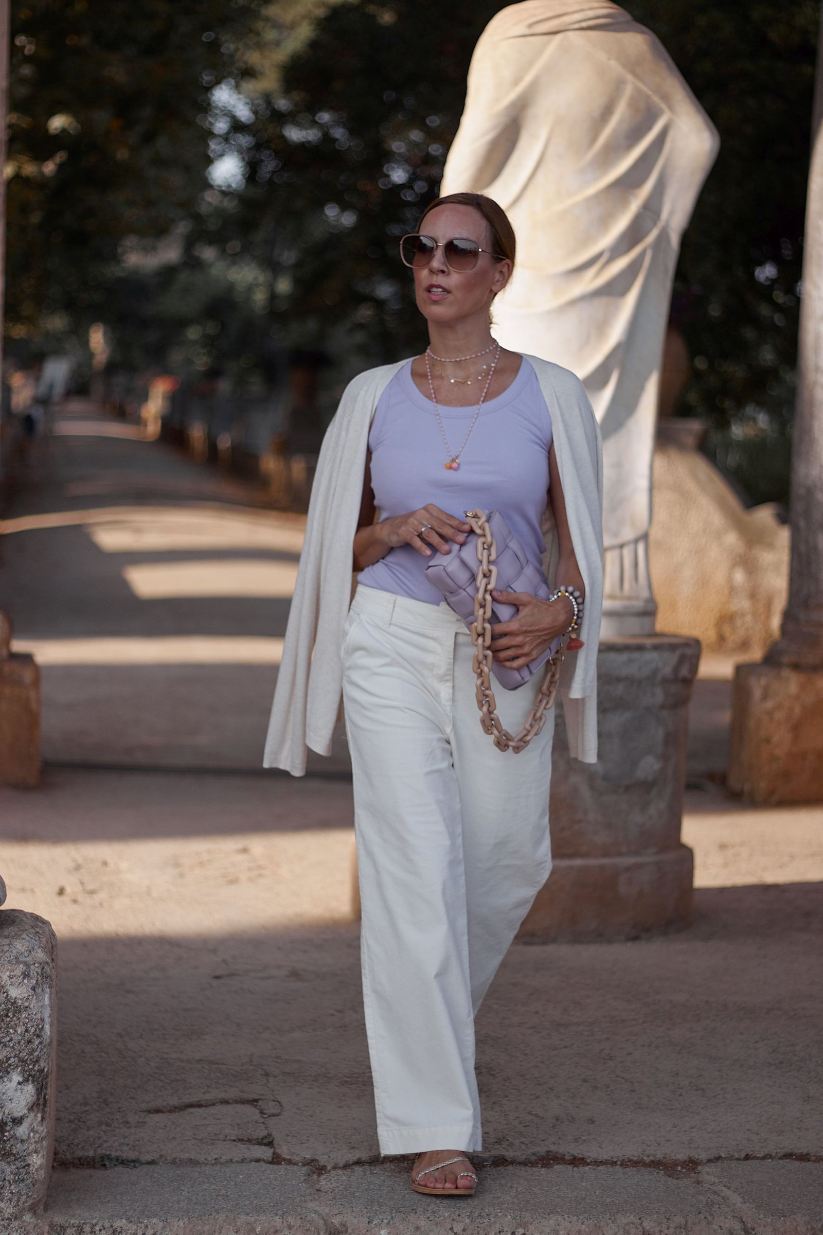 Woman wearing pale purple with neutral separates in a street-style outfit